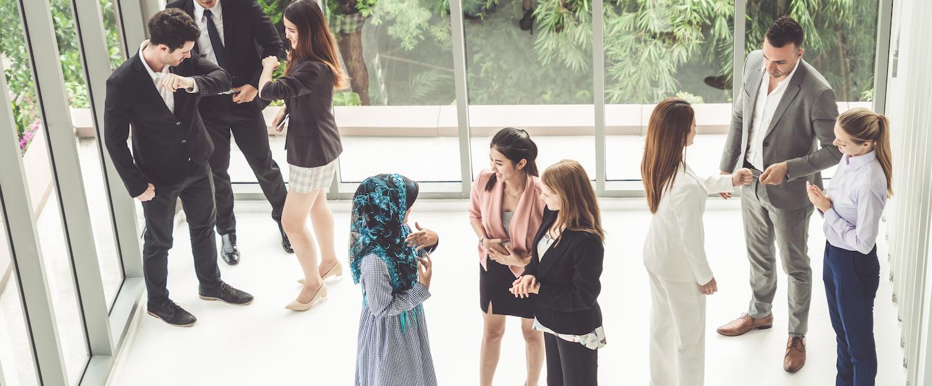 Diverse group of people smile and exchange words after they hear opening words