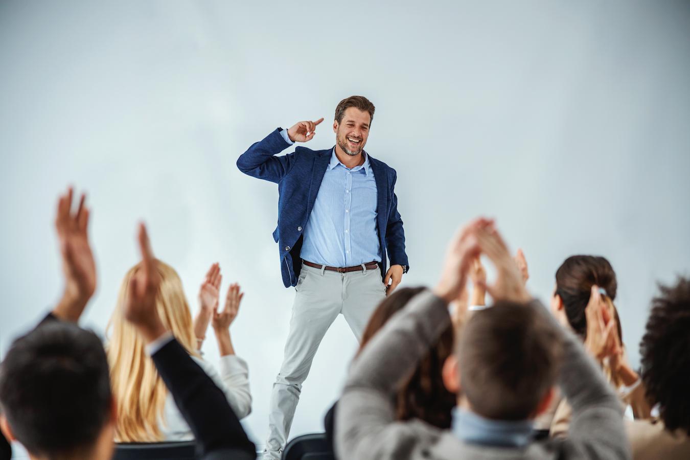 Effective communicator exudes self confidence while audience claps