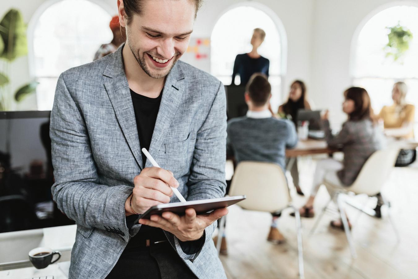 Employee holds tablet and works on color coding a schedule of appointments