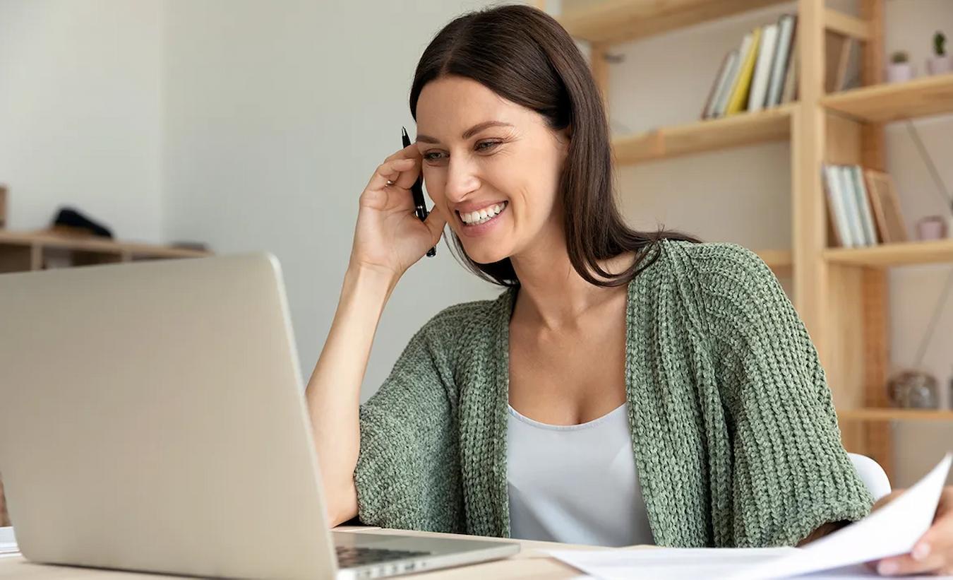 girl smiling at her laptop at home team member online interactive workshop fun way remote teams other team members in person