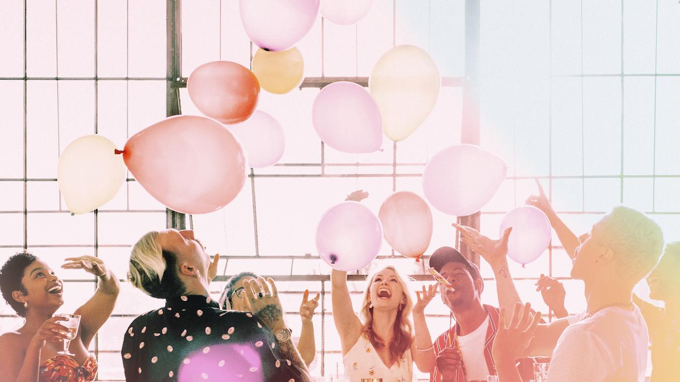 Group celebrates birthday with pink balloons