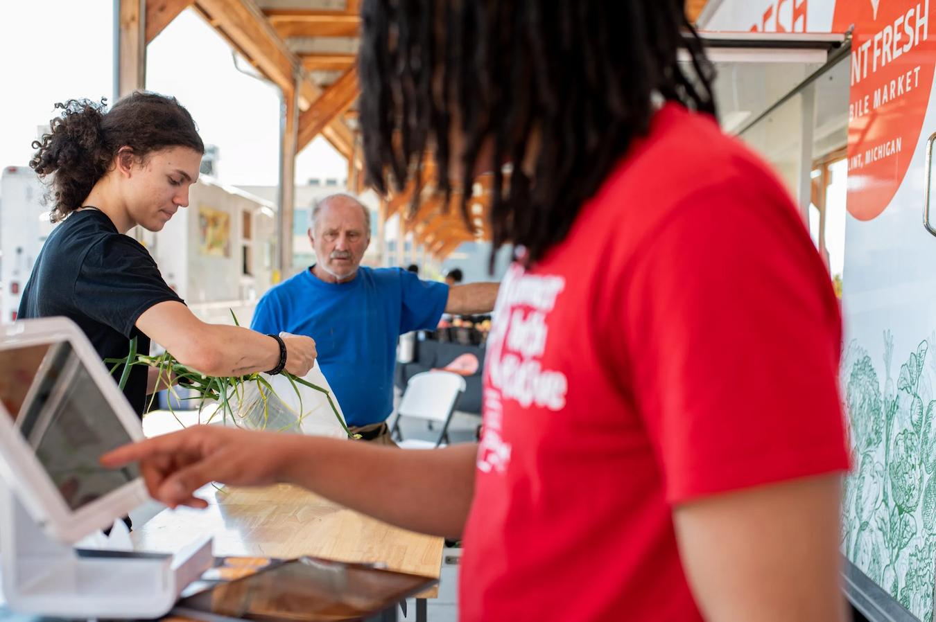 man in red shirt working at a digital register workouts rest hot tools world tasks busy achieving crucial teams holiday lunch