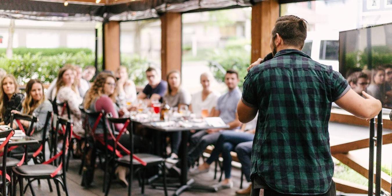 man speaking in front of a small crowd at an event summertime sad in the summer sleep problems social pressure feel worse social media winter depression