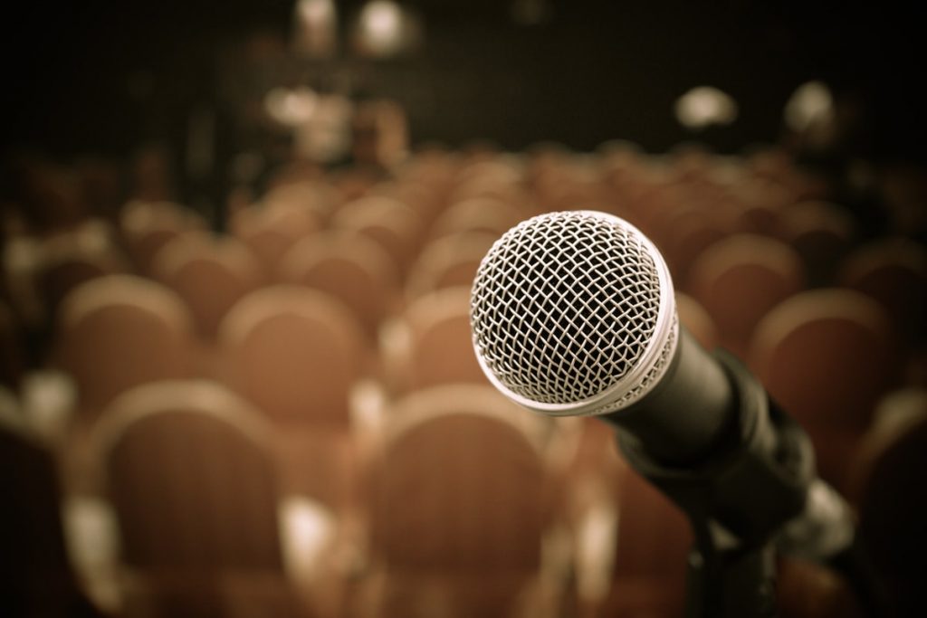 photo of a mic at an event before introducing funny speaker
