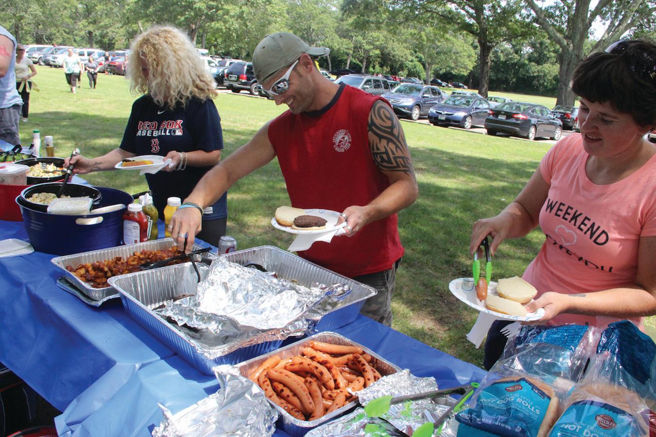 people getting food at a picnic buffet summer team building activities outdoor space fun way in person all the details in person outdoor concert