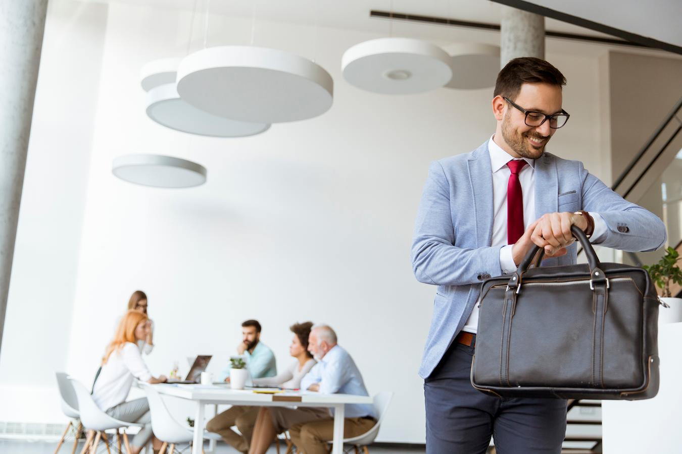 Person in glasses and blue blazer demonstrates better work life balance by leaving a meeting on time