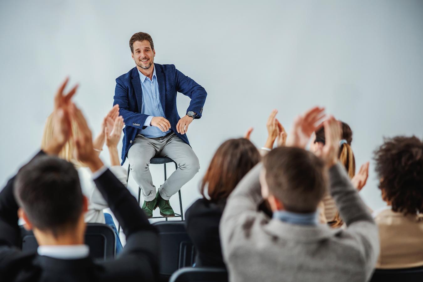 Person onstage shows speakers how to engage audience and deliver a speech they will focus on