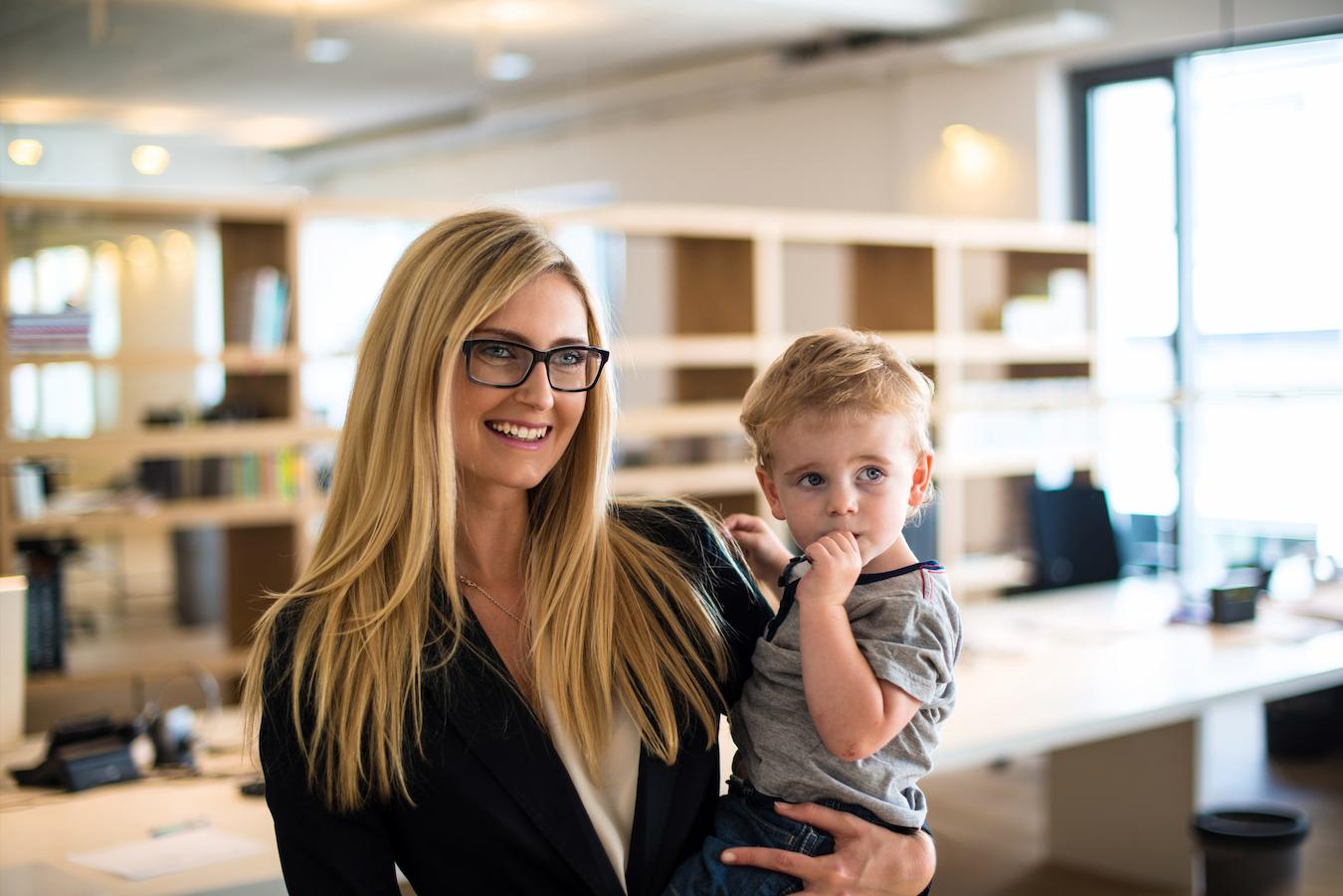 Person with blonde hair and glasses is happy with a better work life balance now that they can pick their child up from day care
