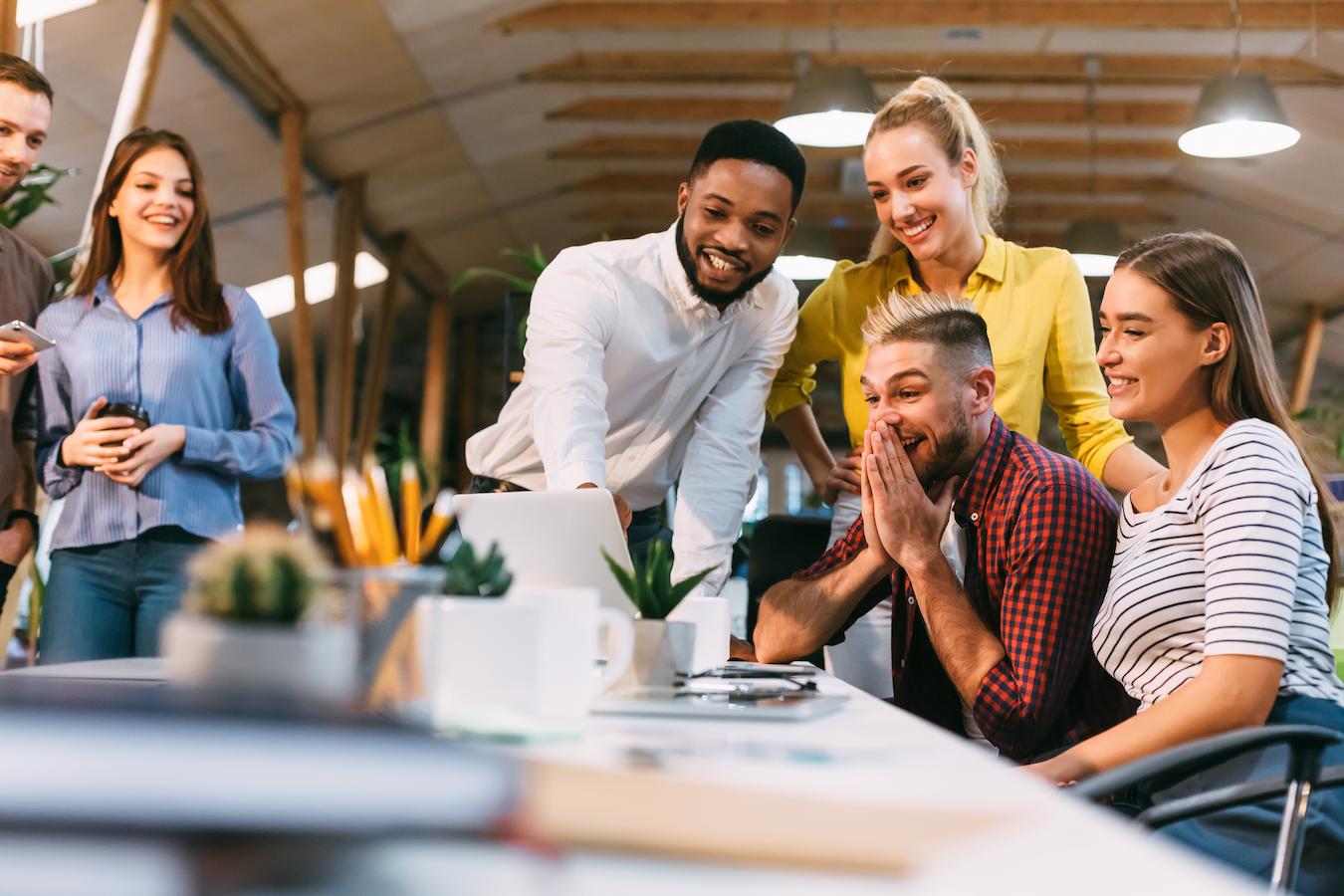 Six coworkers build good rapport and a strong relationship with one another as they establish connection over a silly video at their business office