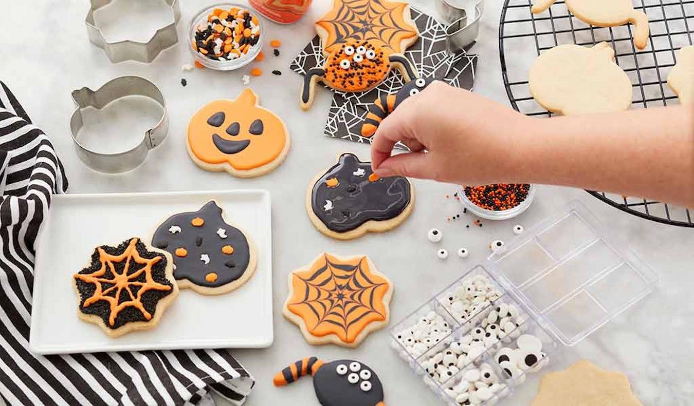 someone decorating halloween styled cookies fall team building activities team morale office window hilarious scottish pub owner hilarious host pumpkin carving new employees fall foliage board games fresh air